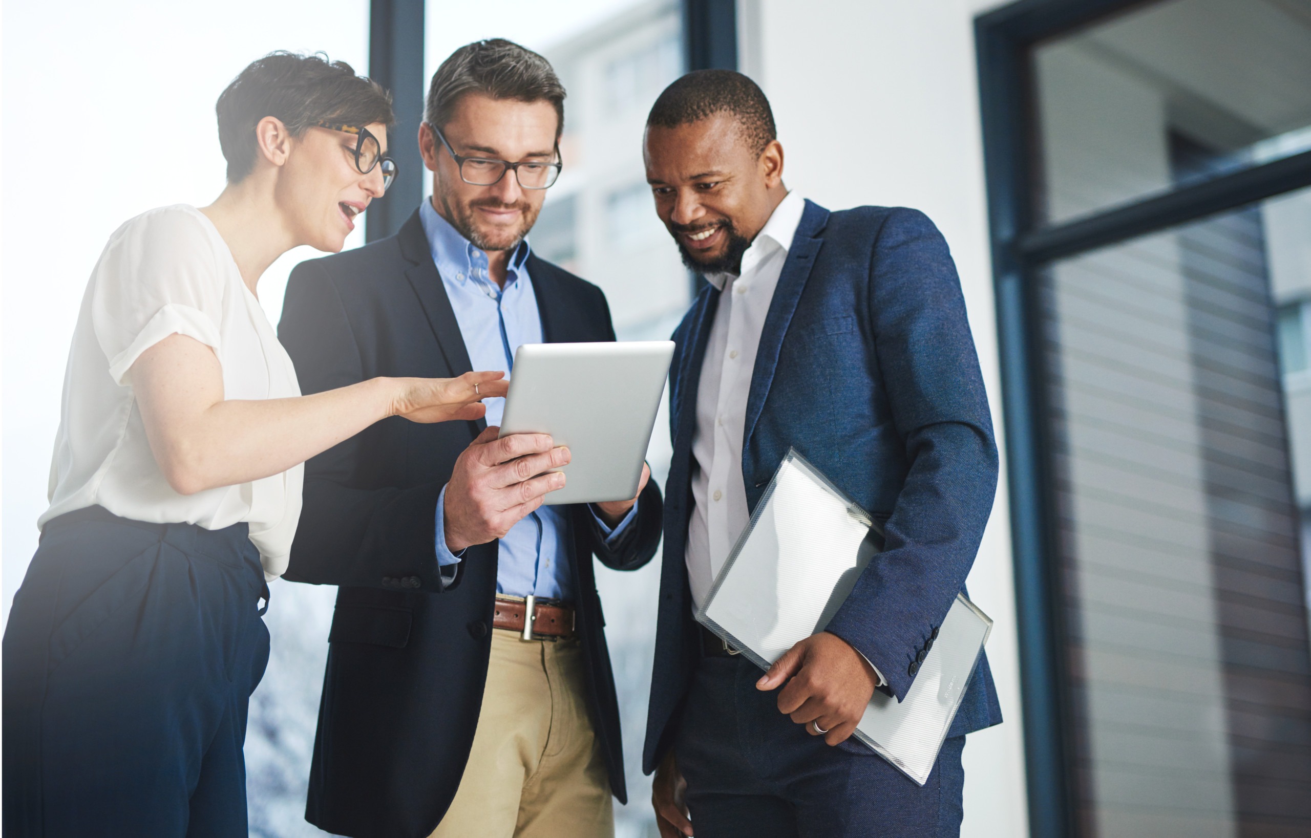 Digitizing business discussions. Shot of a team of colleagues using a digital tablet together at work. Der Digital Shift: Wie moderne Technologien Ihre Unternehmensnachfolge transformieren